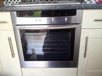 A freshly cleaned built-in oven in a cream fitted kitchen